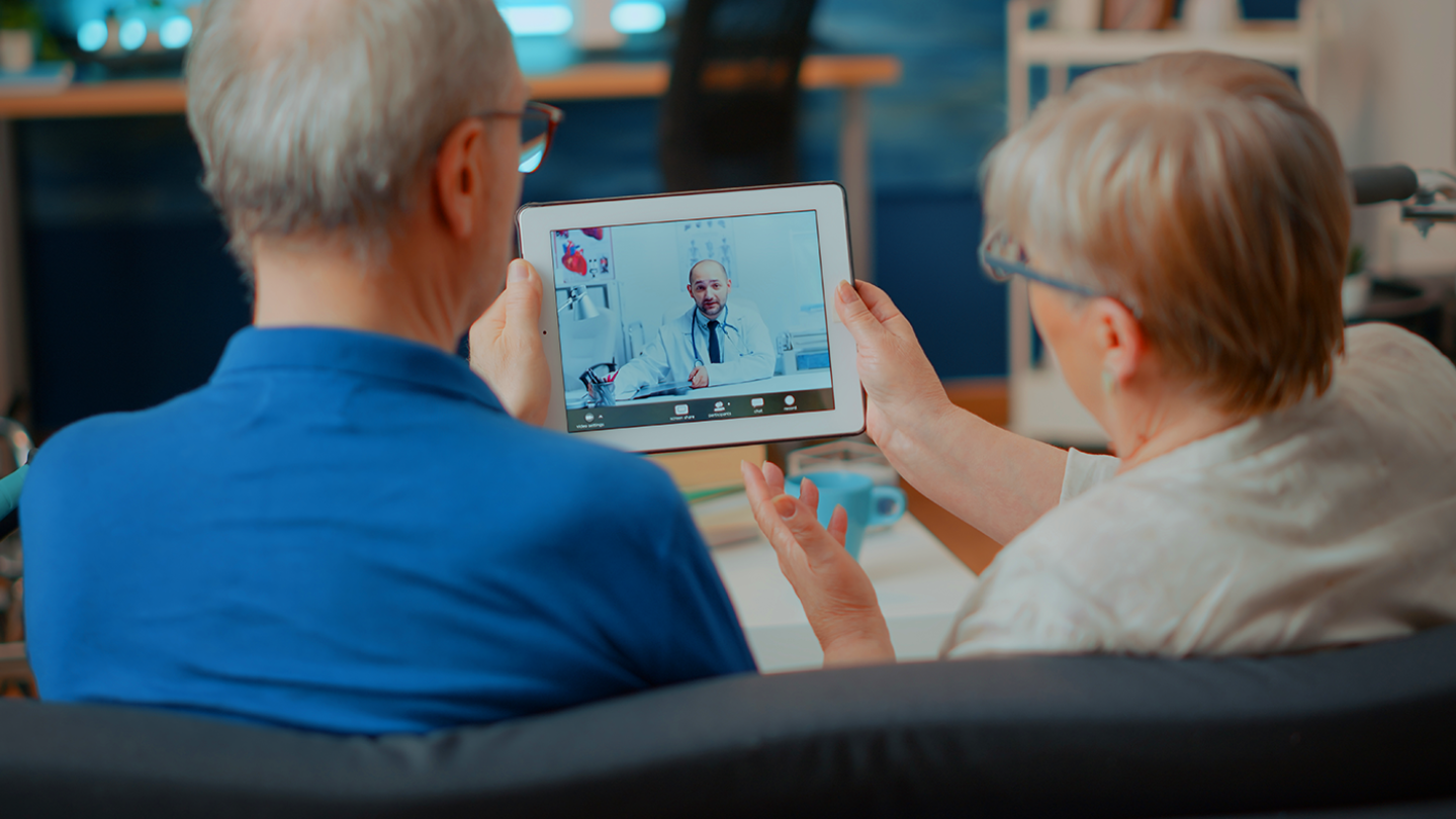 Two people looking at doctor on tablet