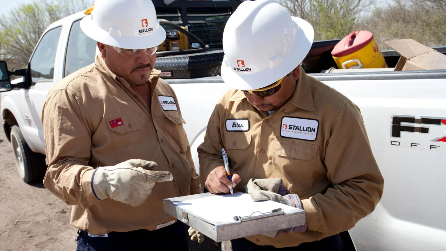Image of two men signing a form